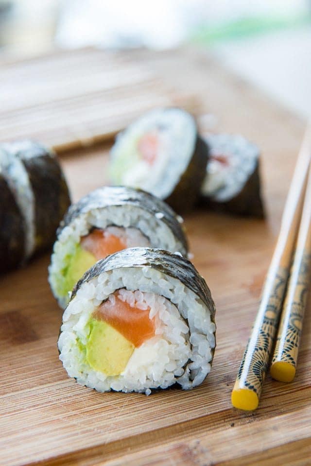 Homemade sushi roll with salmon, cream cheese, and avocado.